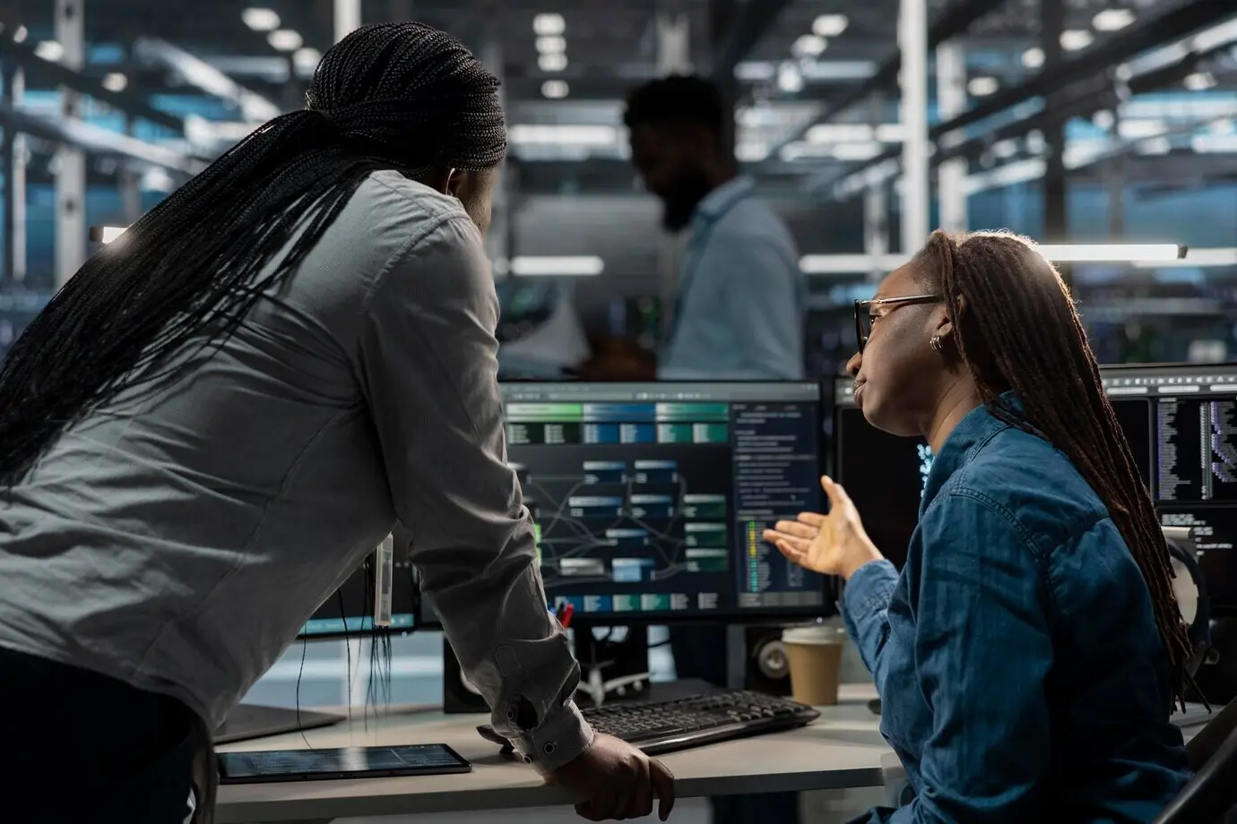 Softwareentwickler in einem Rechenzentrum verwenden einen PC, um neuronale Netze der KI zu visualisieren.