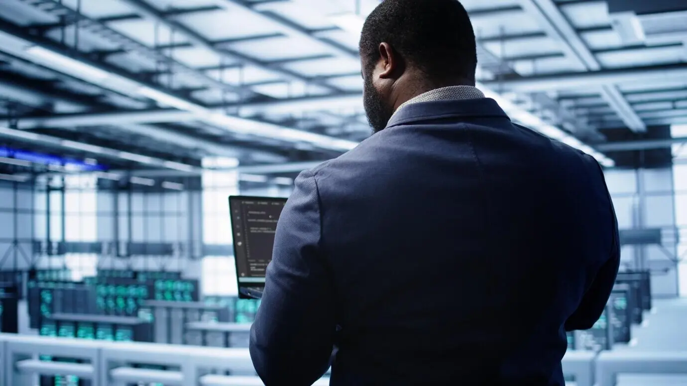 Programmierer im Rechenzentrum, der mit einem Laptop die jährliche Wartungsüberprüfung durchführt.